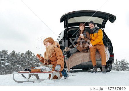 Winter portrait of a family sit on car trunk enjoy their vacation in forest 87787649