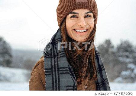 Woman in winter warm jacket walking in snowy winter forest Woman in winter warm jacket walking in snowy winter forest 87787650