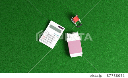 平面上に置かれたミニチュアのベッドと車イス、および電卓の3Dレンダリングイラスト 87788051