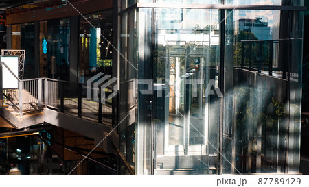 Sunlight through Glass elevator with no people in shopping mall 87789429