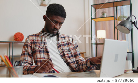 Young man guy using laptop computer sitting at table working, online shopping from home office Young man guy using laptop computer sitting at table working, online shopping from home office 87789660
