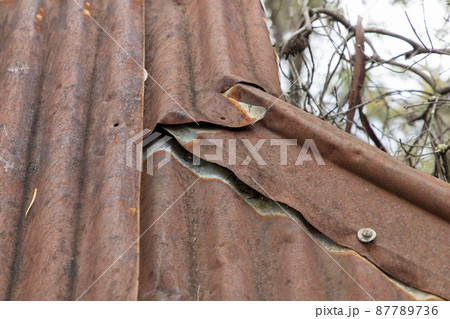 Photograph of an old and damaged rusty roof on a shelter in The Blue Mountains in Australia 87789736