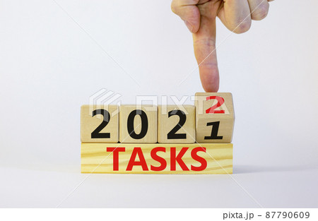 Business concept of planning 2022 tasks symbol. Businesman turns a wooden cube and changes words 'Tasks 2021' to 'Tasks 2022'. Beautiful white background, copy space. Business and tasks 2022 concept. 87790609