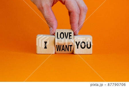 I love and want you symbol. Psychologist turns wooden cubes and changes words I want you to I love you. Beautiful orange table orange background, copy space. Psychological i love and want you concept. 87790706