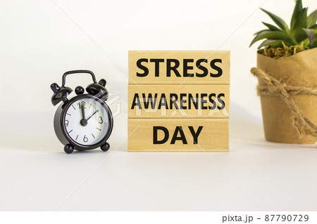Stress awareness day symbol. Wooden blocks with words 'Stress awareness day'. Beautiful white background. Black alarm clock. Psychological, business and stress awareness day concept. Copy space. Stress awareness day symbol. Wooden blocks with words 'Stress awareness day'. Beautiful white background. Black alarm clock. Psychological, business and stress awareness day concept. Copy space. 87790729
