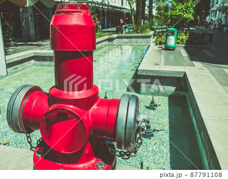 fire hydrant is located on the street of the city. bright, orange fire hydrant to put out fires. safety of citizens, regular water supply to equipment 87791108