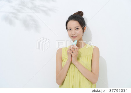 スマートフォンを持つ女性　白背景 87792054