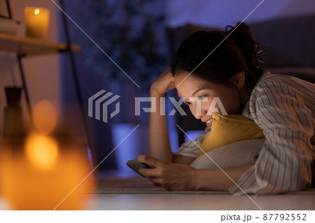 スマホを持つ女性　深夜 87792552