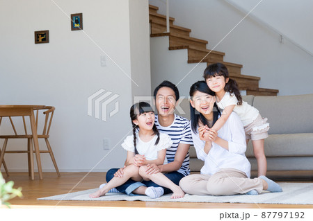 リビングでくつろぐ若い家族 87797192