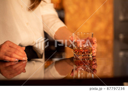 カウンターでお酒を提供する女性　BAR 87797236