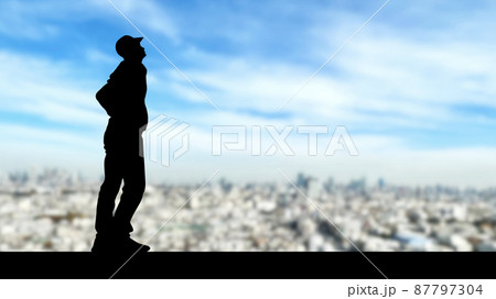 空を見上げる男性シルエット_都会背景_ワイド 空を見上げる男性シルエット_都会背景_ワイド 87797304
