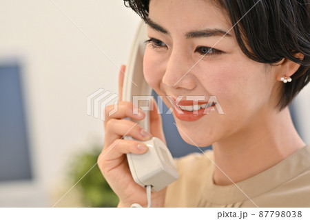 受話器を持って電話をする女性 受話器を持って電話をする女性 87798038