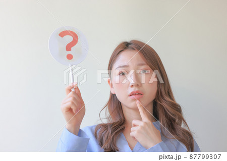 はてなのプレートを持ち悩んでいる女性1 はてなのプレートを持ち悩んでいる女性1 87799307