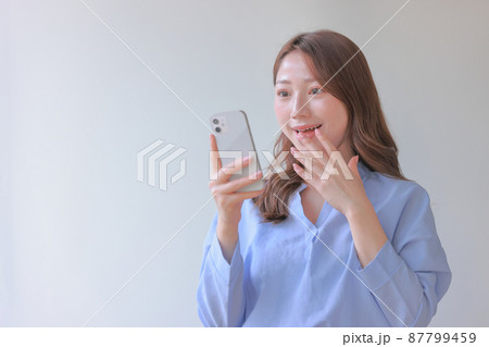 スマホを見て嬉しい驚きの女性2 スマホを見て嬉しい驚きの女性2 87799459