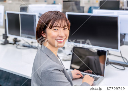 フリーアドレスのオフィスで仕事をする女性 87799749