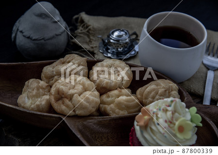 Breakfast time . Choux cream with cupcake and tea on wooden background. Breakfast time . Choux cream with cupcake and tea on wooden background. 87800339