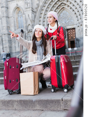 girl with mother holding map outdoors 87800520
