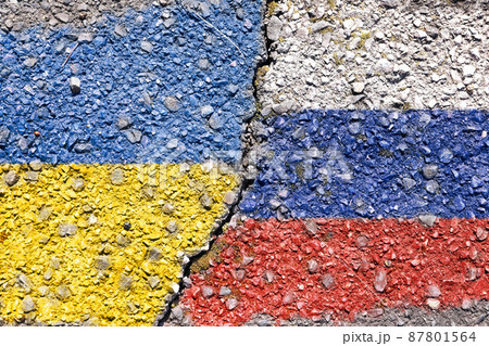 ひび割れたアスファルトに描かれたウクライナ国旗とロシア国旗 87801564