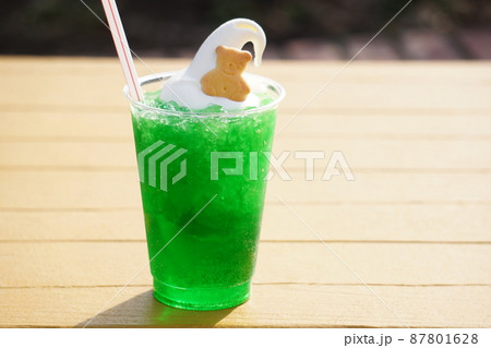 夏のカフェテラスのテーブルの上にあるクッキー付きのクリームメロンソーダ 夏のカフェテラスのテーブルの上にあるクッキー付きのクリームメロンソーダ 87801628