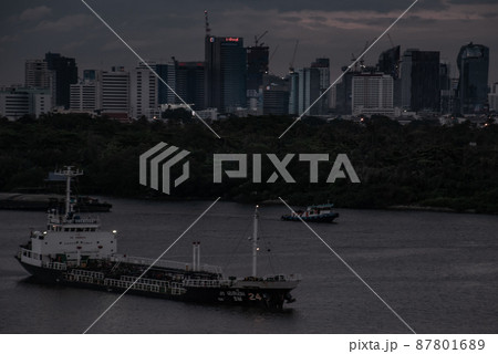 Chao Phraya River view, has cargo ships docked at the middle river. The background is skyscraper in the business district in Bangkok. 87801689
