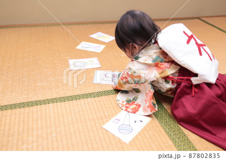 1歳の誕生日に袴を着て一升餅を背負って選び取りをする子供 87802835