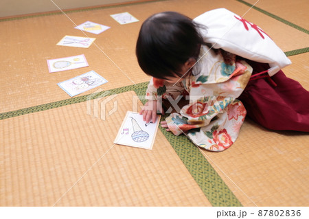 1歳の誕生日に袴を着て一升餅を背負って選び取りをする子供 87802836