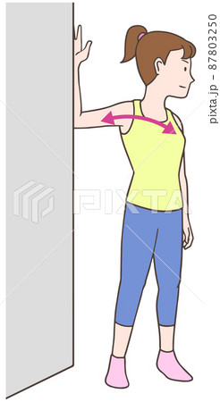 壁を使って大胸筋のストレッチをする女性 87803250