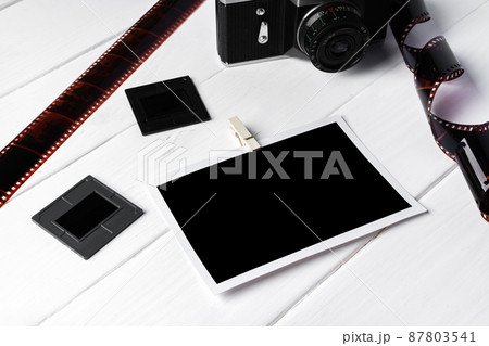 Old retro camera and photos on white wooden background 87803541