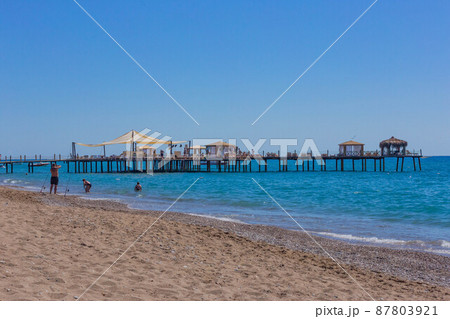 Pier and beach on a clear day with blue sea Pier and beach on a clear day with blue sea 87803921