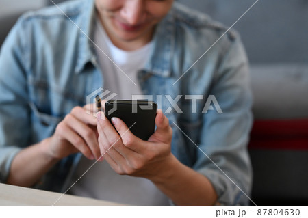 Happy asian man using mobile phone, paying for online purchase via mobile banking while shopping on internet. 87804630