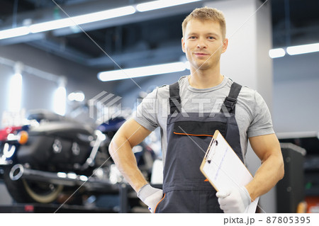 Qualified maintenance service worker in uniform, man with clipboard paper Qualified maintenance service worker in uniform, man with clipboard paper 87805395