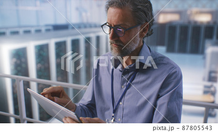 Mature man using tablet in data center 87805543