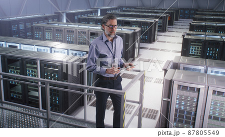 Mature man using tablet in data center Mature man using tablet in data center 87805549