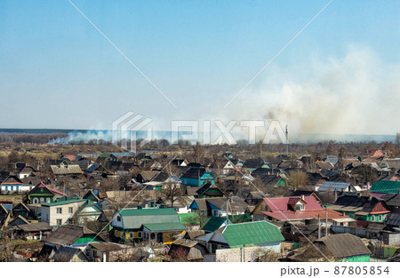 Thick pillar of smoke against a blue sky from forest fires and burning dry grass, copy space 87805854