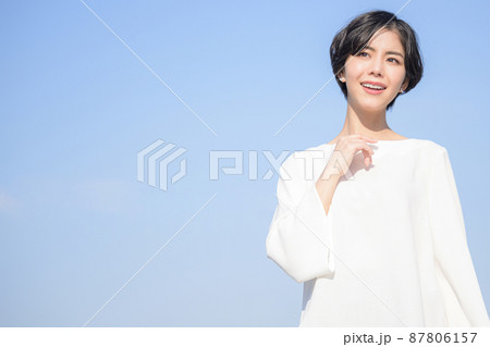 青空バックで上を見つめ考える美しい女性 青空バックで上を見つめ考える美しい女性 87806157