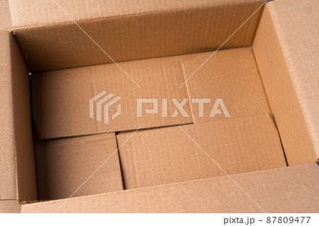 Cardboard box on beige background in studio 87809477