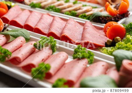 Platter of fresh meat cold cuts on table 87809499