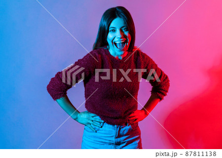 Happy emotions, hilarious laughter. Neon light portrait of joyful carefree woman holding belly and laughing out loud after hearing very funny story, good joke, anecdote. indoor studio shot isolated Happy emotions, hilarious laughter. Neon light portrait of joyful carefree woman holding belly and laughing out loud after hearing very funny story, good joke, anecdote. indoor studio shot isolated 87811138