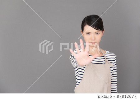 手を出して制止するエプロンの女性 手を出して制止するエプロンの女性 87812677