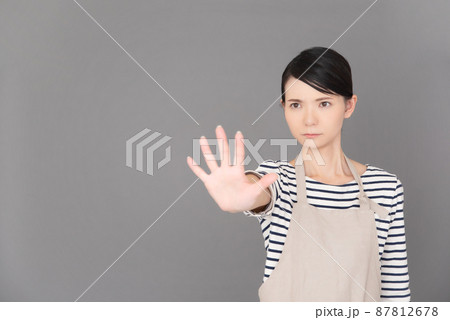 手を出して制止するエプロンの女性 手を出して制止するエプロンの女性 87812678