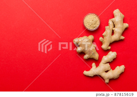 Finely dry Ginger powder in bowl with green leaves isolated on colored background. top view flat lay 87815619