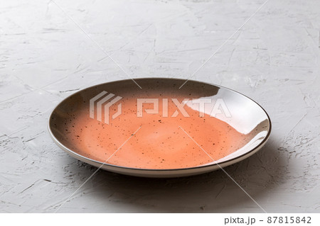 Perspective view of empty red plate on cement background. Empty space for your design Perspective view of empty red plate on cement background. Empty space for your design 87815842