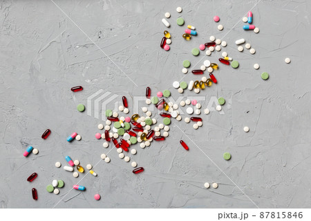 assorted pills and tablets top border over colored background. Many different pills and space for text on colorful background, top view 87815846