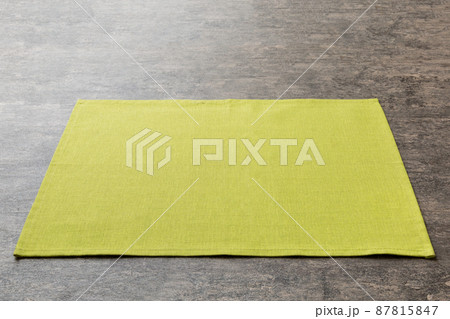 Perspective view of green tablecloth for food on cement background. Empty space for your design 87815847