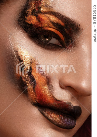 Portrait of a beautiful woman with creative fire art make-up on her face. 87815955