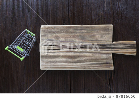 Empty cutting board on wooden brown background Empty cutting board on wooden brown background 87816650