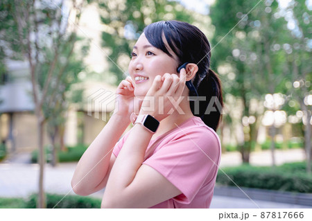 骨伝導イヤホンで音楽を楽しむスポーツウェアの女性 骨伝導イヤホンで音楽を楽しむスポーツウェアの女性 87817666