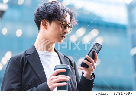 若い男性　スマホ　コーヒー 87817697