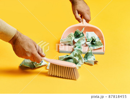 Creative layout with male hand sweeping money dollar bills on yellow background 87818455