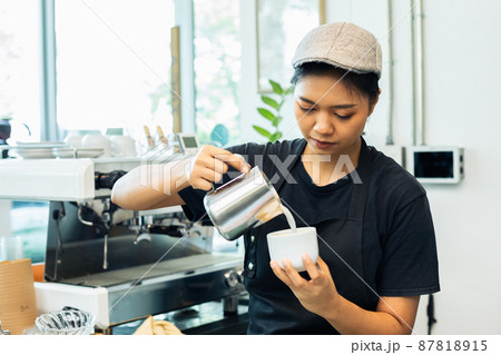 woman barista wear apron uniform making coffee in cafe counter serve for customer. 87818915